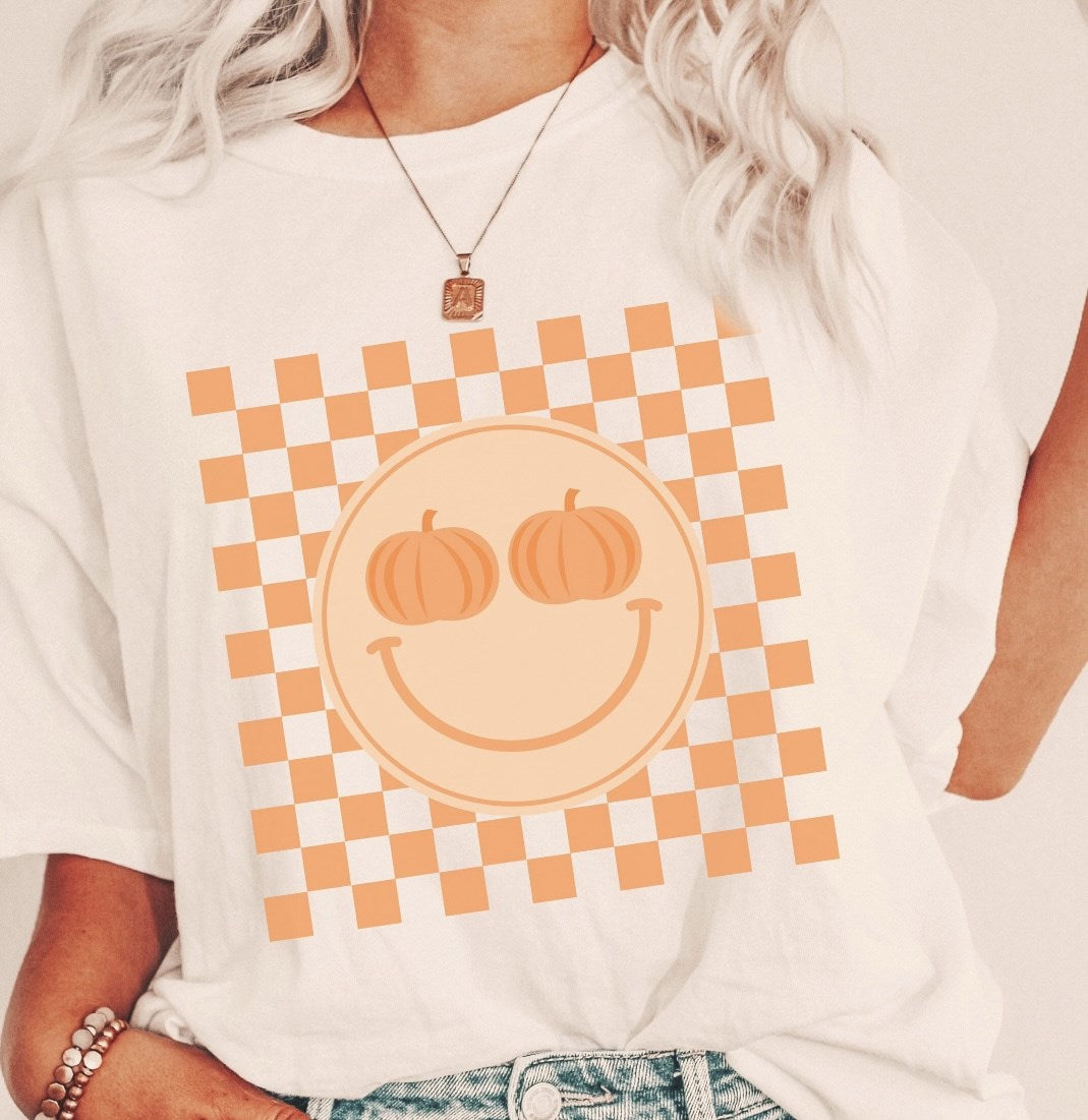 Smiley Face With Pumpkin Eyes & Checkered Background Tee